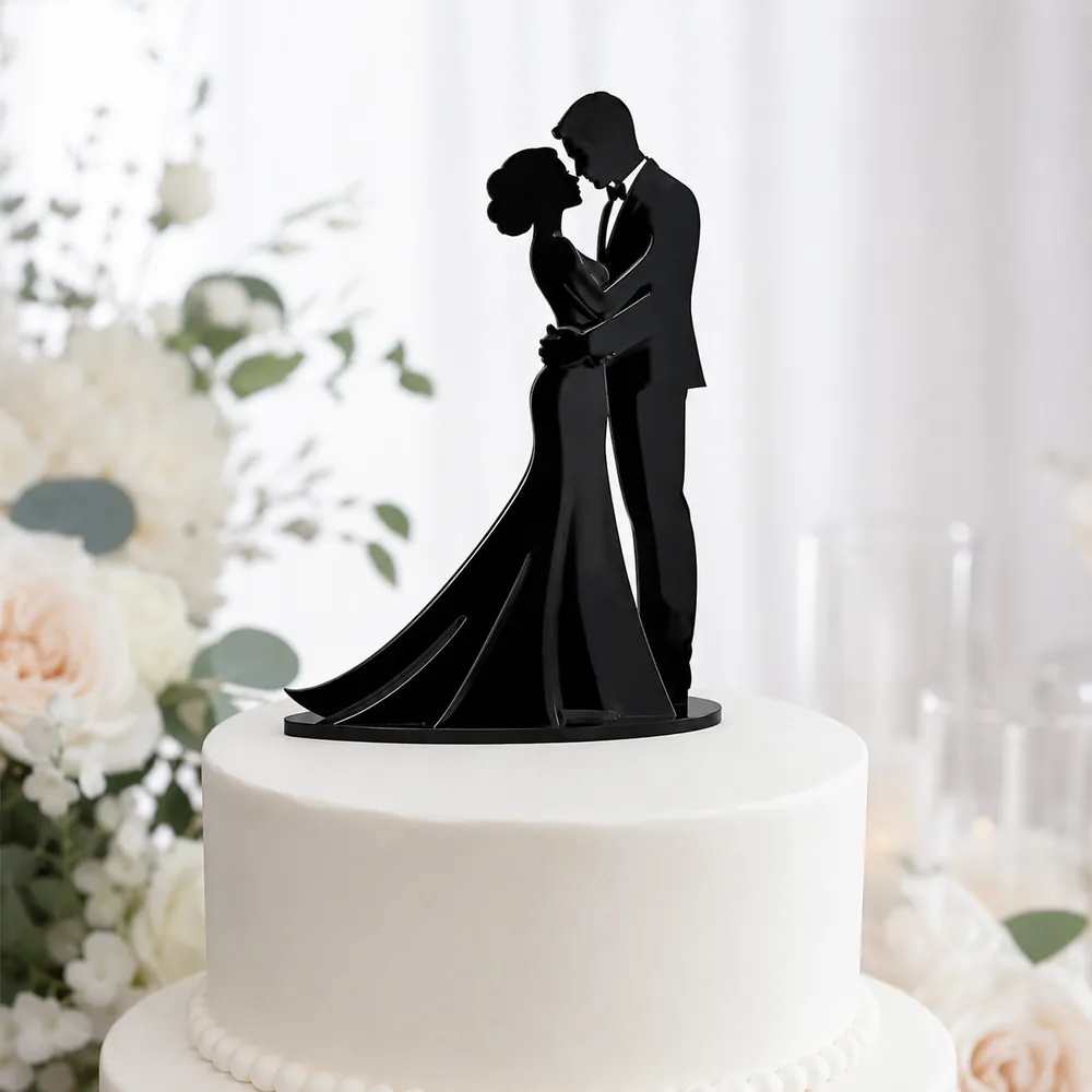Black acrylic silhouette cake topper of a bride and groom in a close embrace